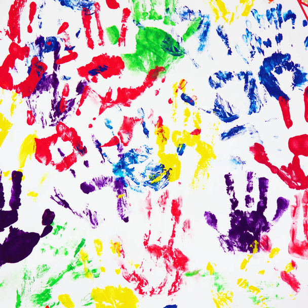 πολύχρωμο handprints σχετικά με το λευκό φόντο ως σύμβολο της ομαδικής εργασίας - Φωτογραφία, εικόνα