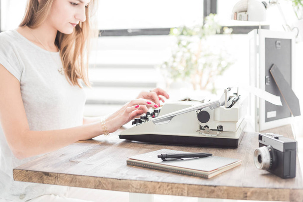 Young business woman working at home and typing on a typewriter. Creative Scandinavian style workspace - Valokuva, kuva
