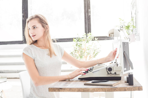 Young business woman working at home and typing on a typewriter. Creative Scandinavian style workspace - Foto, Imagem
