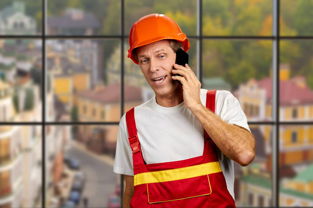 Trabajador manual hablando por teléfono celular
. - Foto, Imagen