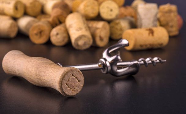 As rolhas de vinho e saca-rolhas na mesa de madeira preta
 - Foto, Imagem