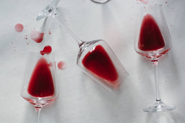 Glasses of spilled red  wine  on white  background,  copy space.  Wine degustation concept - Foto, afbeelding