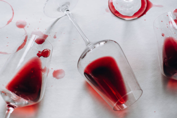 Glasses of spilled red  wine  on white  background,  copy space.  Wine degustation concept - Photo, Image