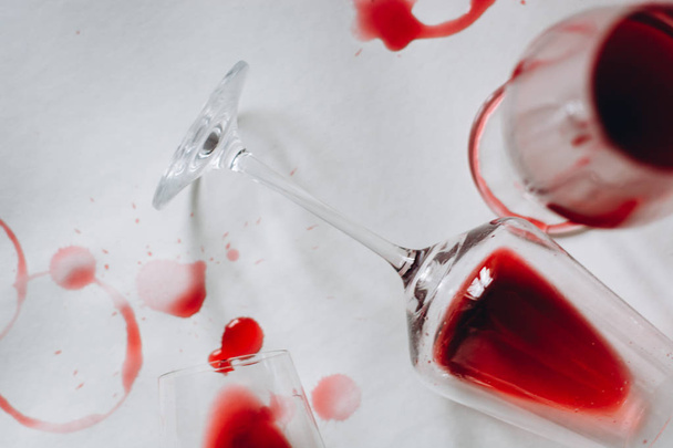 Glasses of spilled red  wine  on white  background,  copy space.  Wine degustation concept - Foto, Imagen
