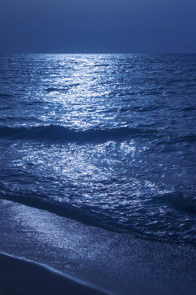Fantástico fondo azul marino. Mar Mediterráneo por la noche. Luna reflejándose en un mar
 - Foto, Imagen