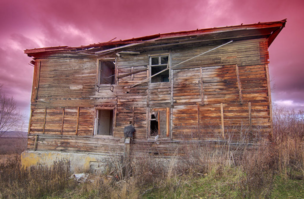 starý ošklivý zchátralý dřevěný dům na pozadí červánky při západu slunce  - Fotografie, Obrázek