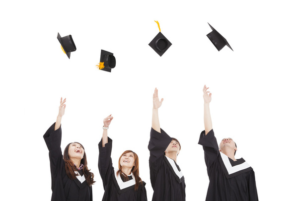 Grupa szczęśliwy młodych absolwentów rzucając kapelusz - Zdjęcie, obraz