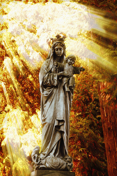 Muinainen Neitsyt Marian patsas Jeesuksen Kristuksen kanssa auringonvalossa
  - Valokuva, kuva