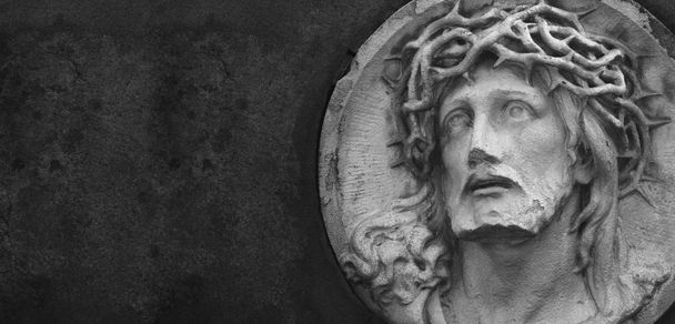 Statua di Gesù Cristo su uno sfondo di pietra grigia con spazio per il testo
 - Foto, immagini