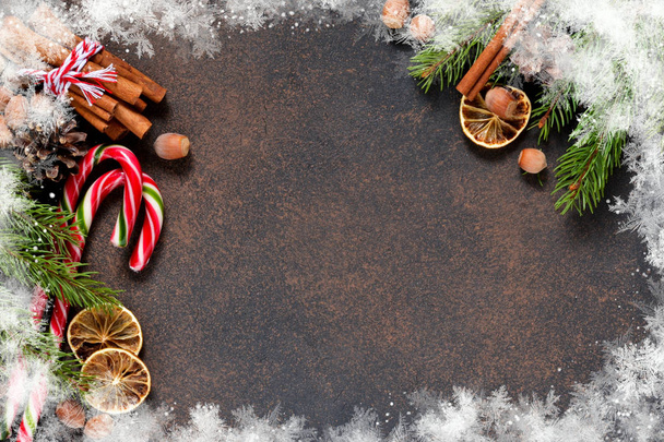 Joulukuusi kanelilla, pähkinöitä, karkkia ruskealla taustalla tilaa tekstin alla
. - Valokuva, kuva