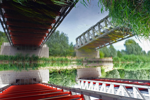 Pintoresco reflejo de puentes en superficie vibratoria del agua
. - Foto, imagen
