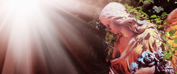 Vista maestosa della statua dell'angelo d'oro illuminata dalla luce del sole su uno sfondo di sfondo scuro. Scena drammatica insolita. Filtro retrò e stile vintage
.  - Foto, immagini