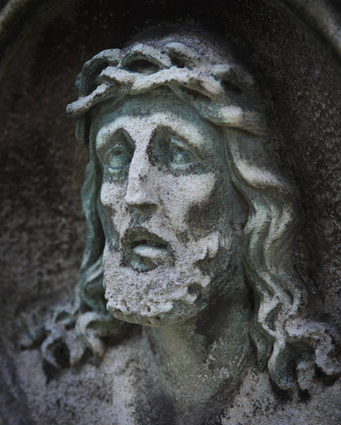 Estátua de Jesus Cristo contra um fundo de pedra cinzenta com espaço para texto
 - Foto, Imagem