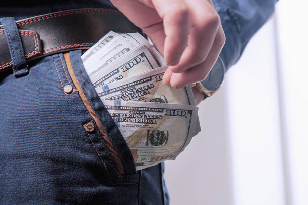 Stealing money from pocket as a symbol of high utility bills (Dollar, deception, attention, fraud concept - Φωτογραφία, εικόνα