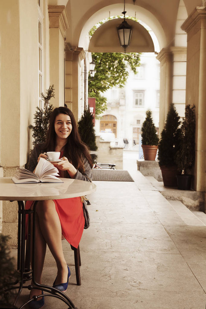 Beautiful young woman reading a book and drinking coffee. (relax, romance, poetry, rest) - Фото, изображение