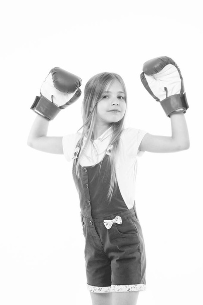 Little girl smile after boxing training isolated on white. Happy child raised hands in boxing gloves. Punching. Childhood development and health. Kid boxer show power. I am the best. Sport and energy - Foto, Bild