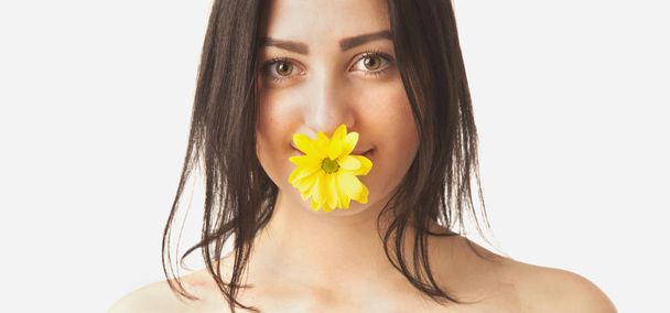 flower in the mouth of a young beautiful girl - Foto, Imagen