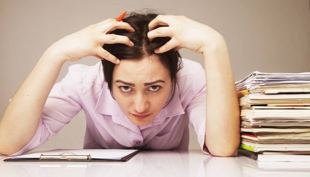 nervous woman working with documents (psychological portrait, aggression, anger, frustration) - 写真・画像