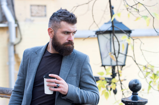 Relaxing coffee break. Hipster hold paper coffee cup and enjoy park environment. Drink it on the go. Man bearded hipster prefer coffee take away. Businessman bearded guy drink coffee outdoors - Φωτογραφία, εικόνα