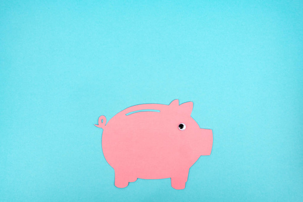 Cut out pink piggy bank on light blue background - Photo, Image