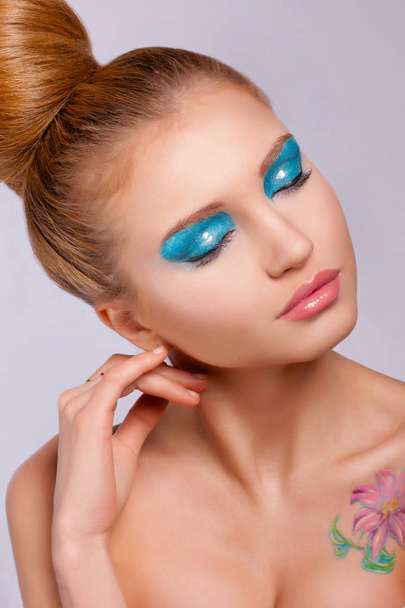 Portret van jonge mooie model met een heldere lente make-up en de gesloten ogen op een zachte kleur achtergrond - Foto, afbeelding