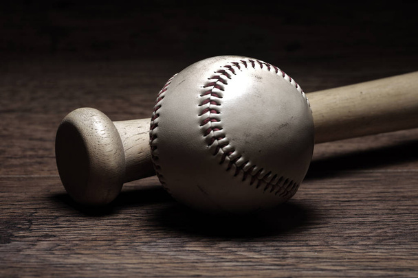 Retro honkbal en vleermuis in kleedkamer op houten bankje - Foto, afbeelding
