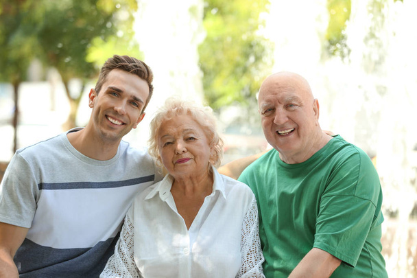 Man with elderly parents outdoors on sunny day - Foto, imagen
