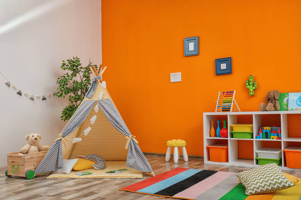 Cozy kids room interior with play tent and toys - Fotó, kép