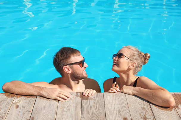 Happy young couple in swimming pool at resort - Foto, imagen