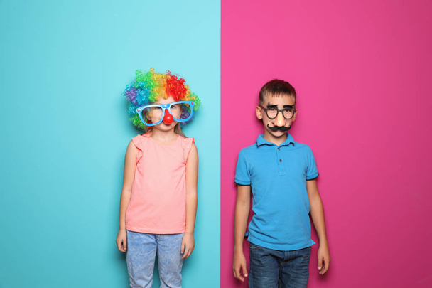 Children in funny disguise ready to celebrate April Fool's day on color background - Photo, Image