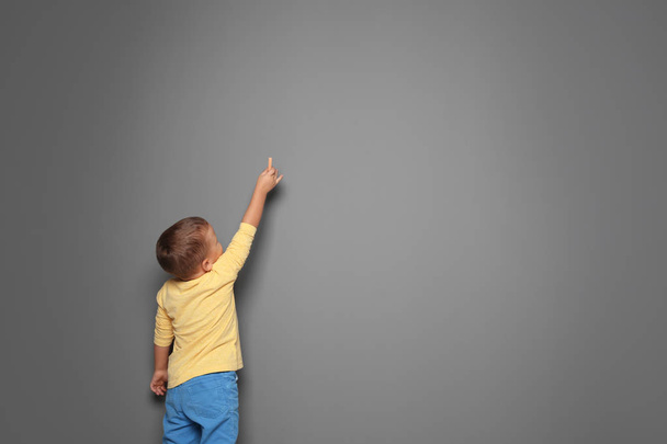 Little boy drawing with colorful chalk on gray background. Space for design - Foto, Bild
