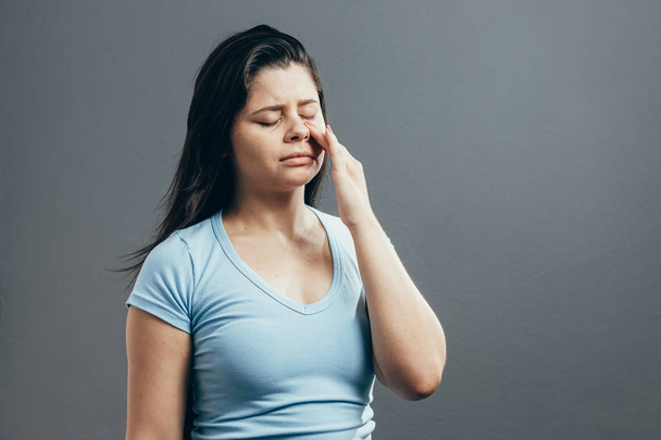 Sinus pain, sinus pressure, sinusitis. Sad woman holding her nose and head because sinus pain - Fotó, kép