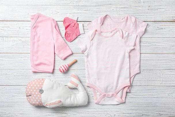 Flat lay composition with stylish baby clothes on wooden background - Fotografie, Obrázek