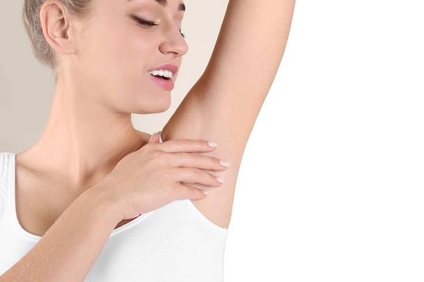 Young woman showing armpit on color background, space for text. Using deodorant - Valokuva, kuva