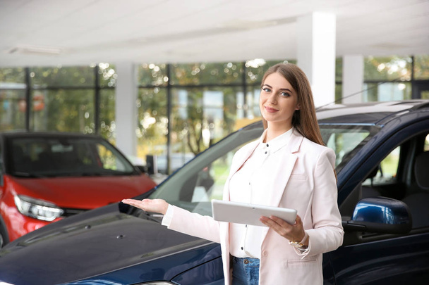Woman with tablet in modern car dealership - Фото, зображення