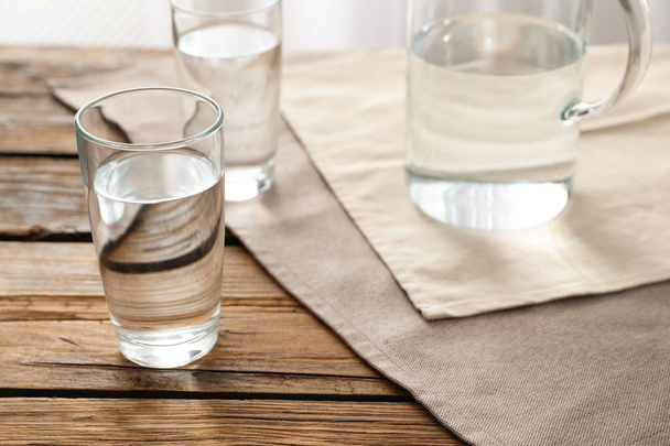 Glassware of fresh water on wooden table - 写真・画像