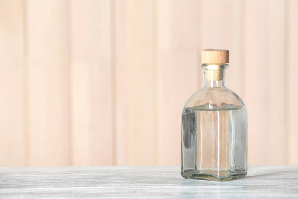 Glass bottle with vinegar on wooden table. Space for text - Photo, image