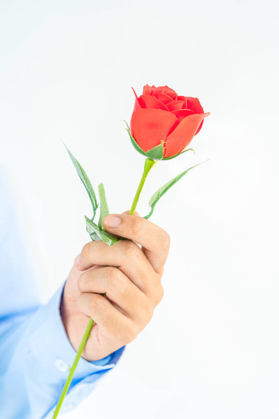 Фотографія чоловіка, що тримає червоні троянди в руках на білому тлі - Фото, зображення