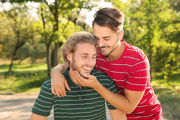 Portrait of happy gay couple smiling in park - 写真・画像