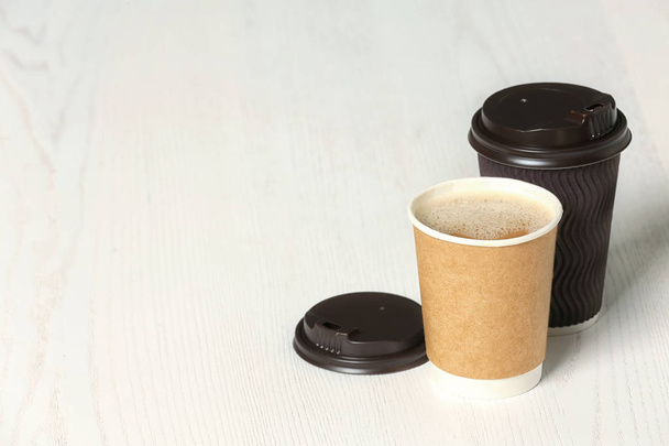 Cardboard cups of coffee on wooden background. Space for text - Photo, Image
