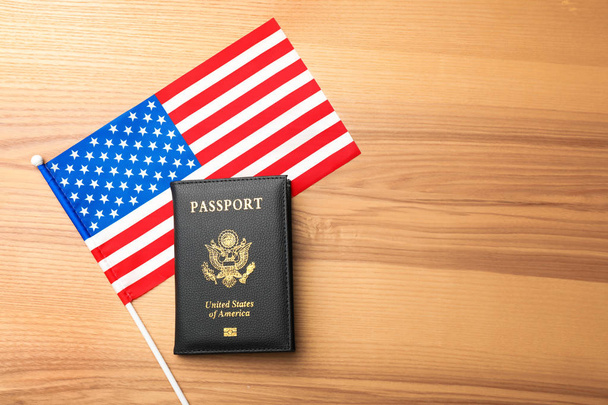 Flat lay composition with flag of USA and passport on wooden background. Space for text - Zdjęcie, obraz