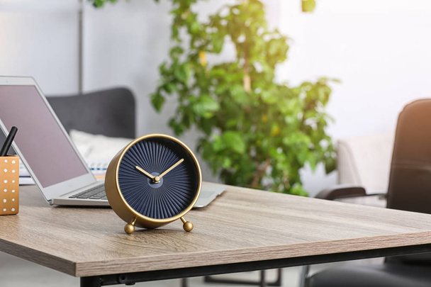 Workplace with stylish analog clock and laptop in office. Space for text - Foto, Imagen