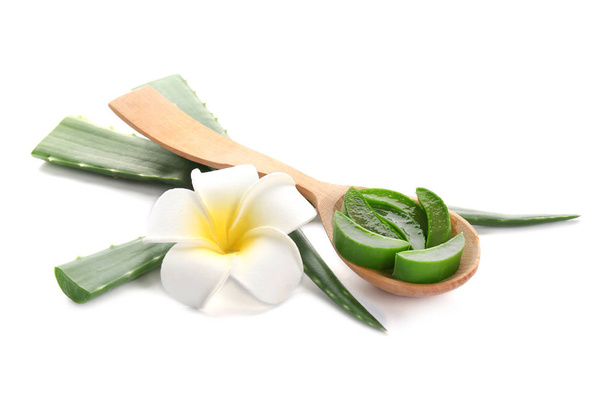 Wooden spoon with pieces of aloe vera and flower on white background - Фото, изображение