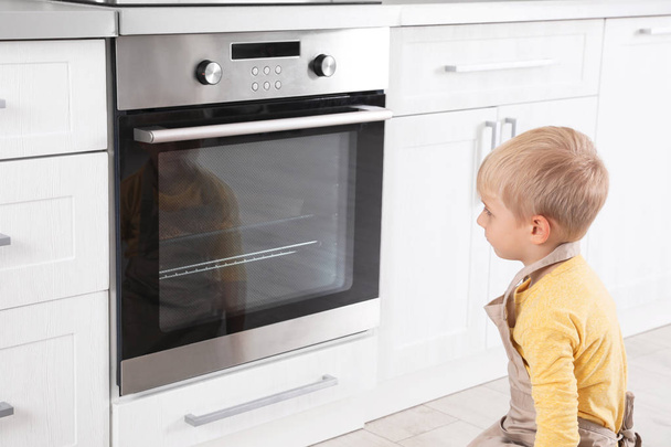 Little boy baking something in oven at home - Valokuva, kuva
