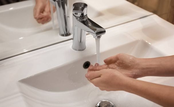 Woman washing hands under tap indoors, closeup - Foto, Imagen