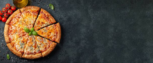 Delicious Italian pizza four cheeses with Basil, tomatoes and olive oil on a dark concrete table. Top view with copy space. Flat lay. banner - Photo, Image