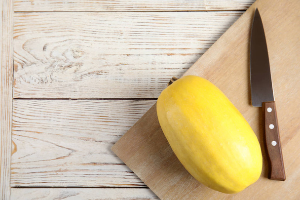 Flat lay composition with spaghetti squash and knife on wooden background. Space for text - Foto, imagen