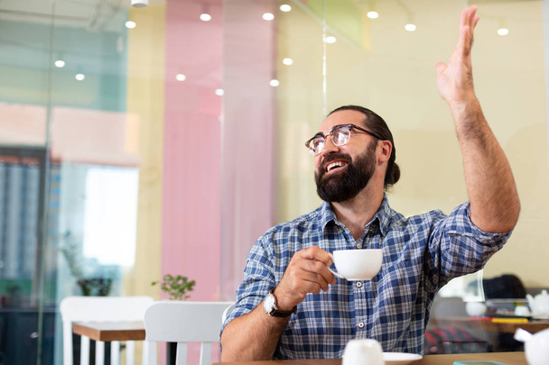 Emotionaalinen parrakas mies tunne innoissaan tavata hänen ystävänsä kahvilassa
 - Valokuva, kuva