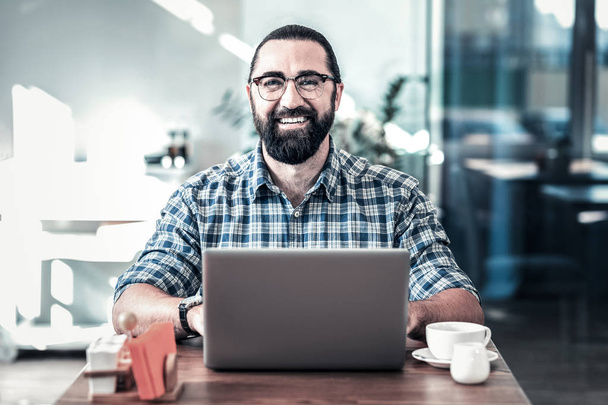 Vidám szakállas férfi mosolyogva sikeres nap után szemüveg - Fotó, kép