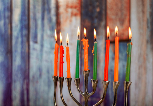 Menorah with colorful burning candles for Hanukkah on light, close up - Photo, Image